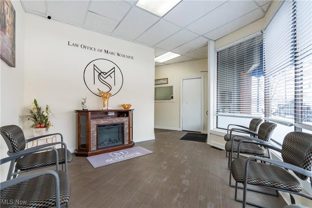 Living room with a paneled ceiling and a high end fireplace