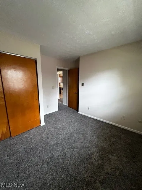 Unfurnished bedroom with carpet and a textured ceiling