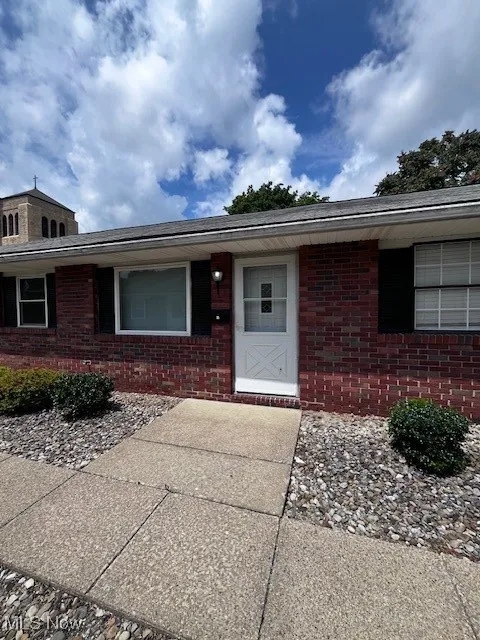 View of exterior entry featuring brick siding