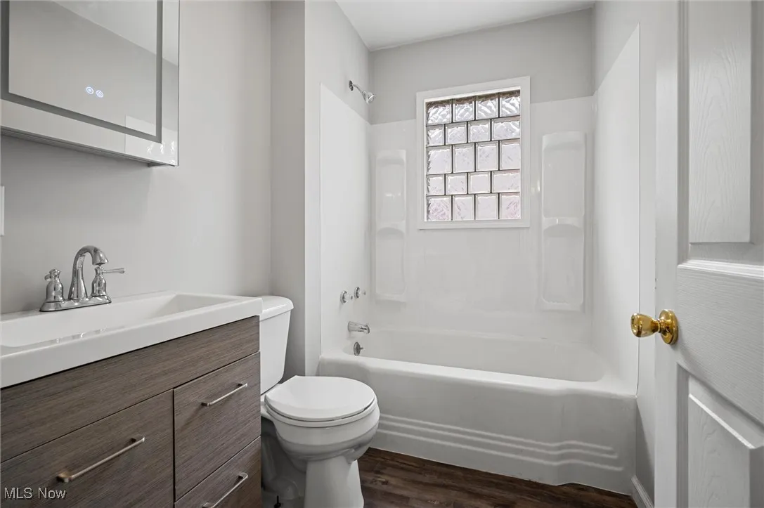 Full bathroom featuring vanity, tub / shower combination, and wood finished floors