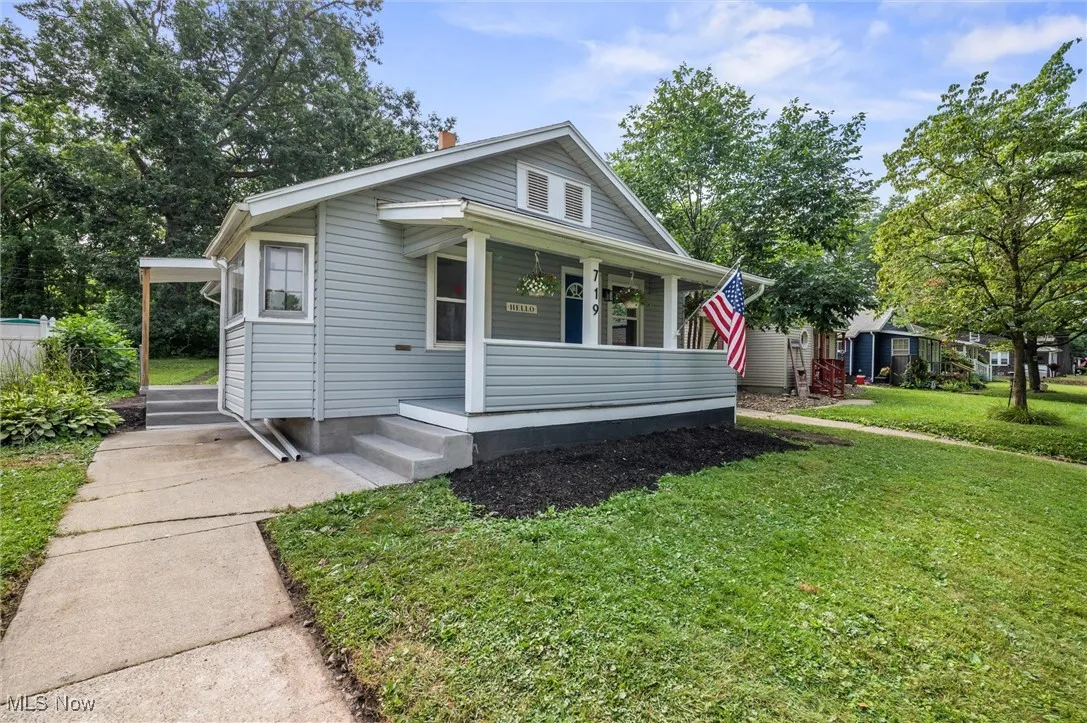 Bungalow-style home with covered porch and a front yard
