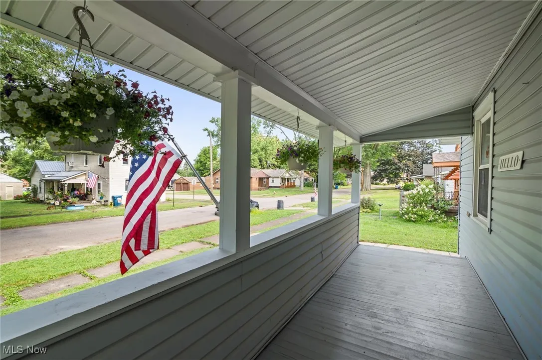 Wooden porch with a residential view and a yard