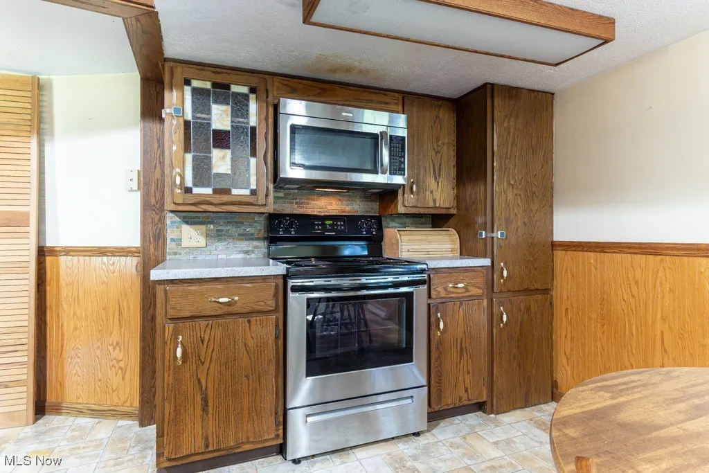Newer stove, pull out shelves in cabinets on right