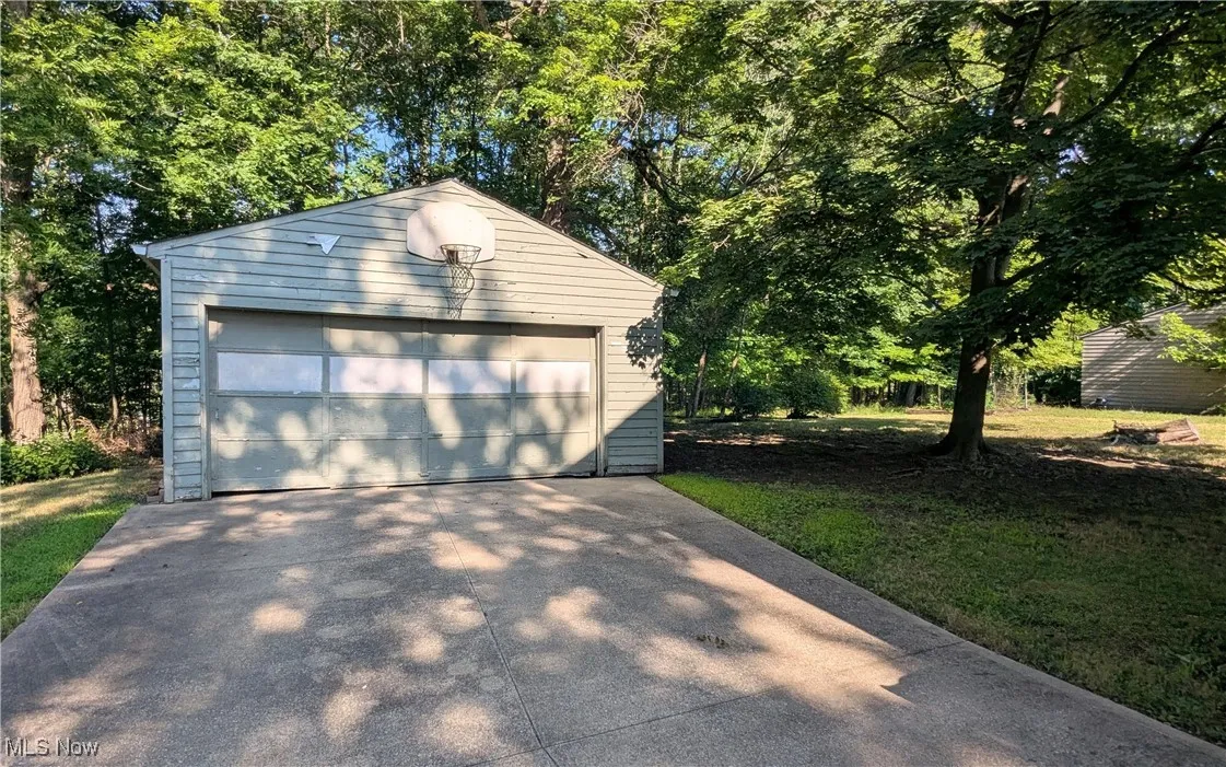 View of 2 car garage and backyard