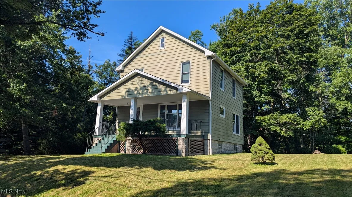 View of front of property with covered front porch and yard