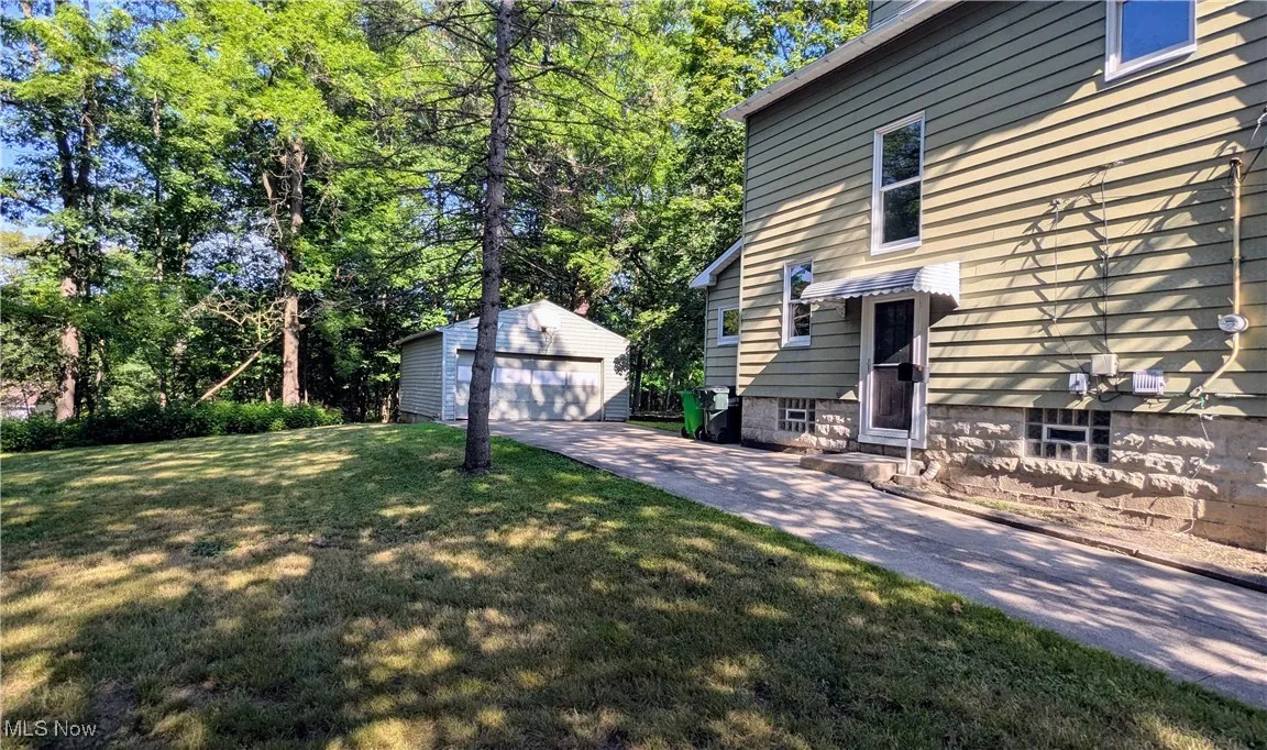 view of side of home with concrete driveway and 2 car garage