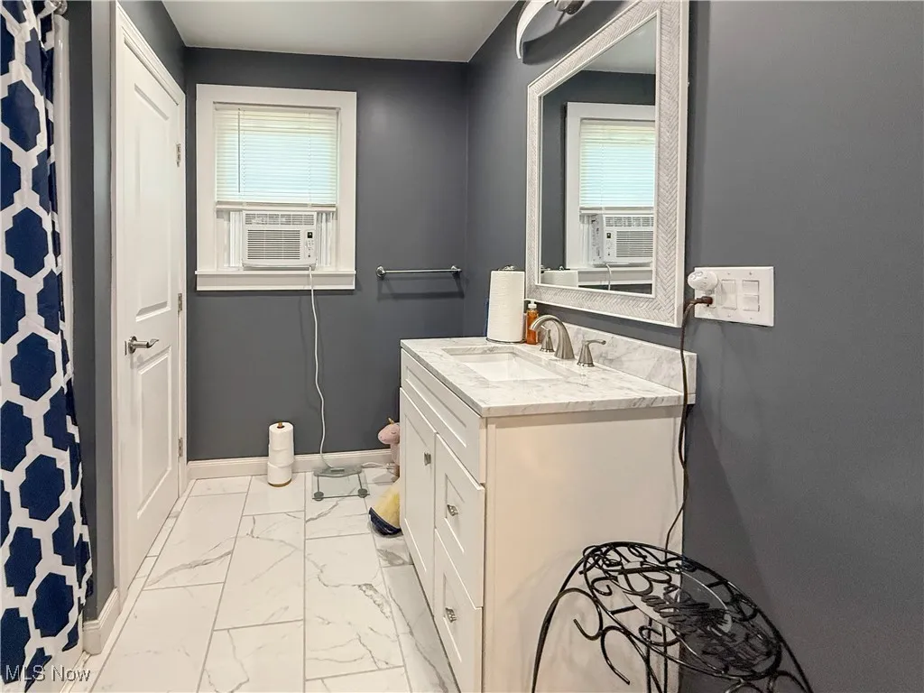 Full bath with marble look tiles, vanity, and cooling unit