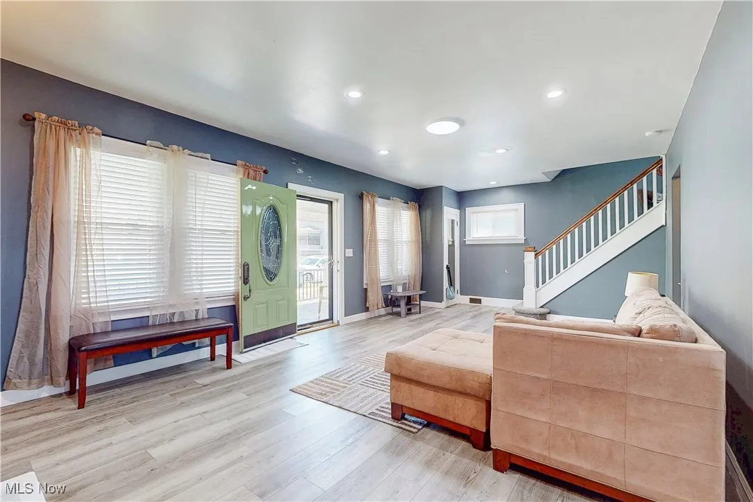 Living room featuring wood finished floors, stairway, and recessed lighting