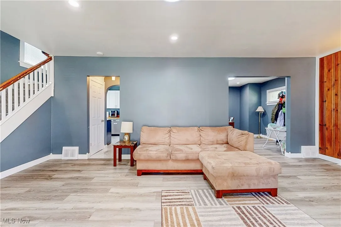 Living area featuring light wood-type flooring, stairs, and recessed lighting