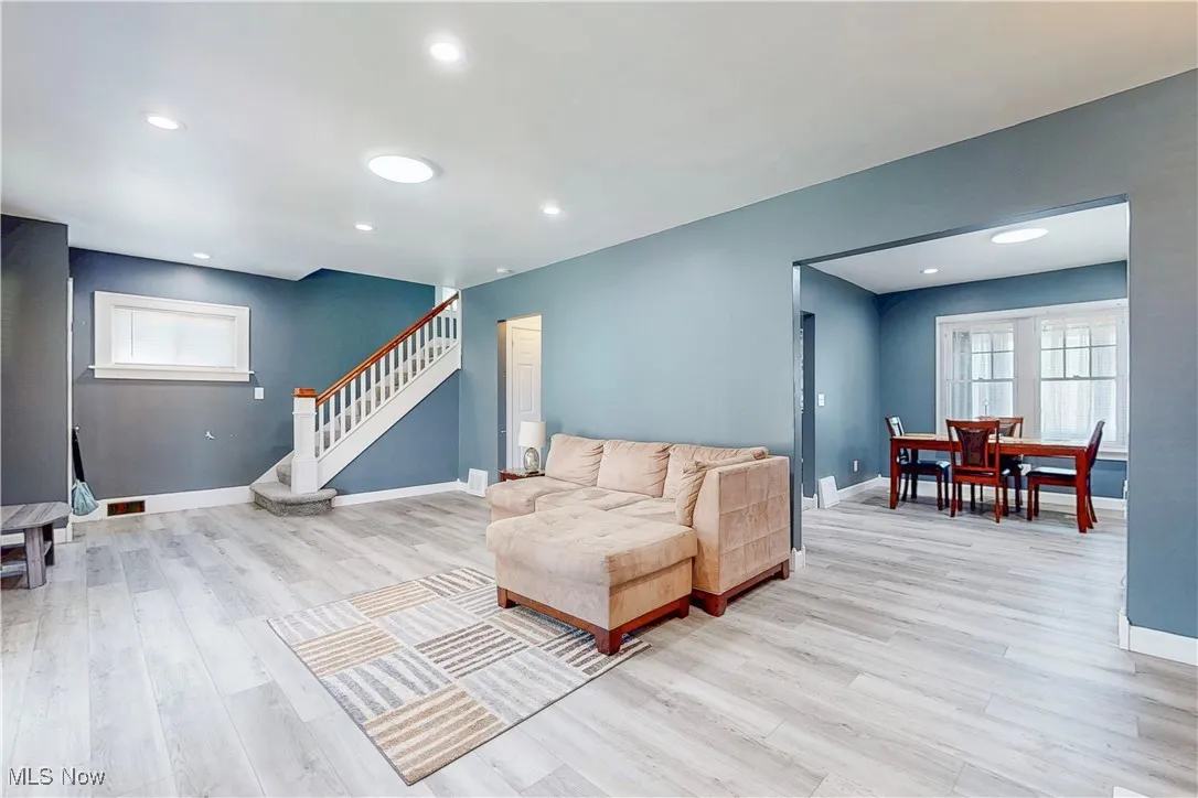 Living area featuring light wood finished floors, stairs, and recessed lighting