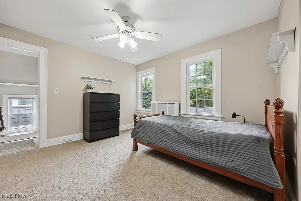 Carpeted bedroom featuring baseboards and ceiling fan