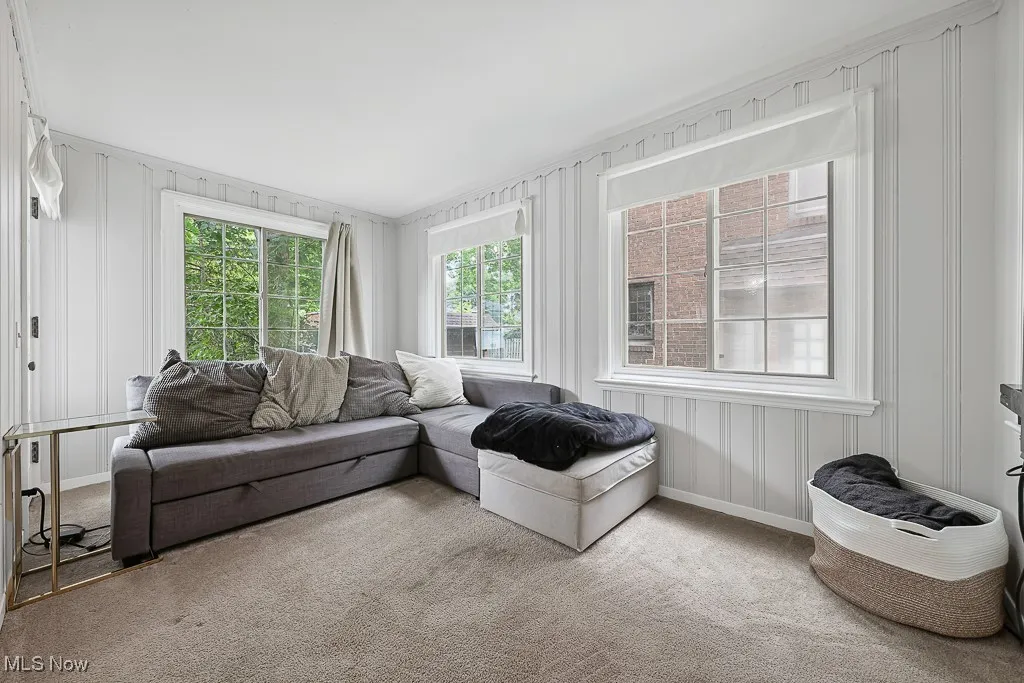 Living room featuring carpet floors and a decorative wall