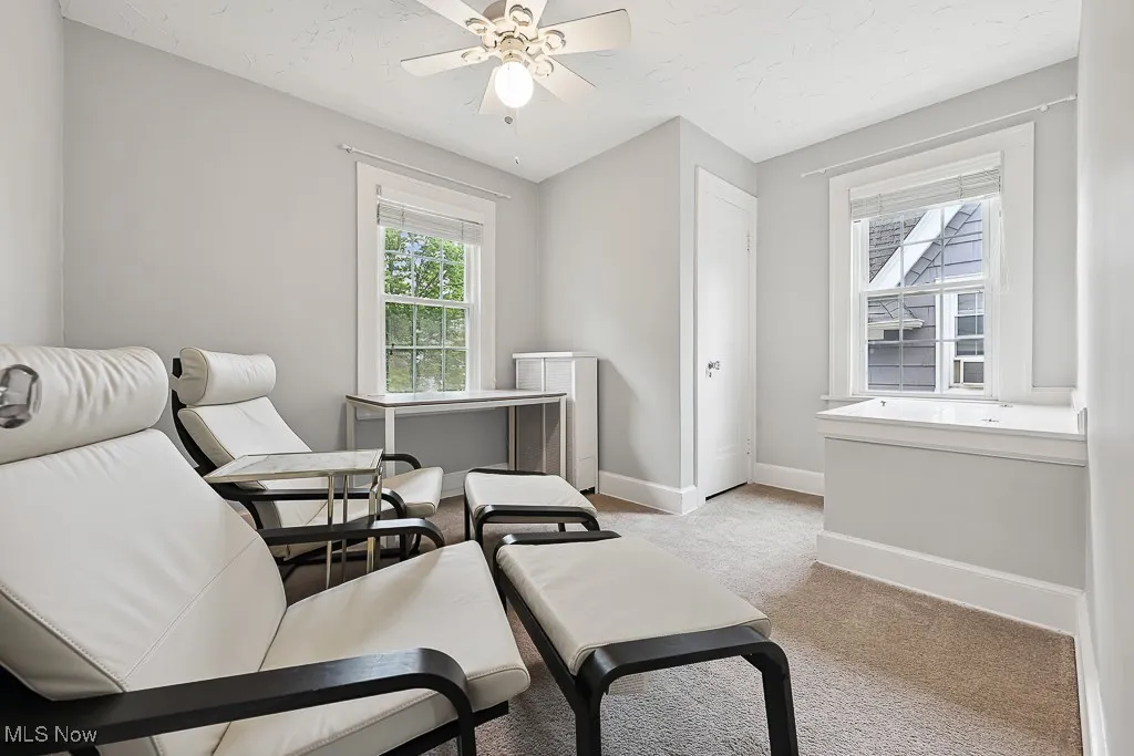 Sitting room with light colored carpet and ceiling fan