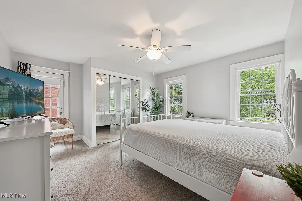 Bedroom featuring light carpet, ceiling fan, and access to exterior