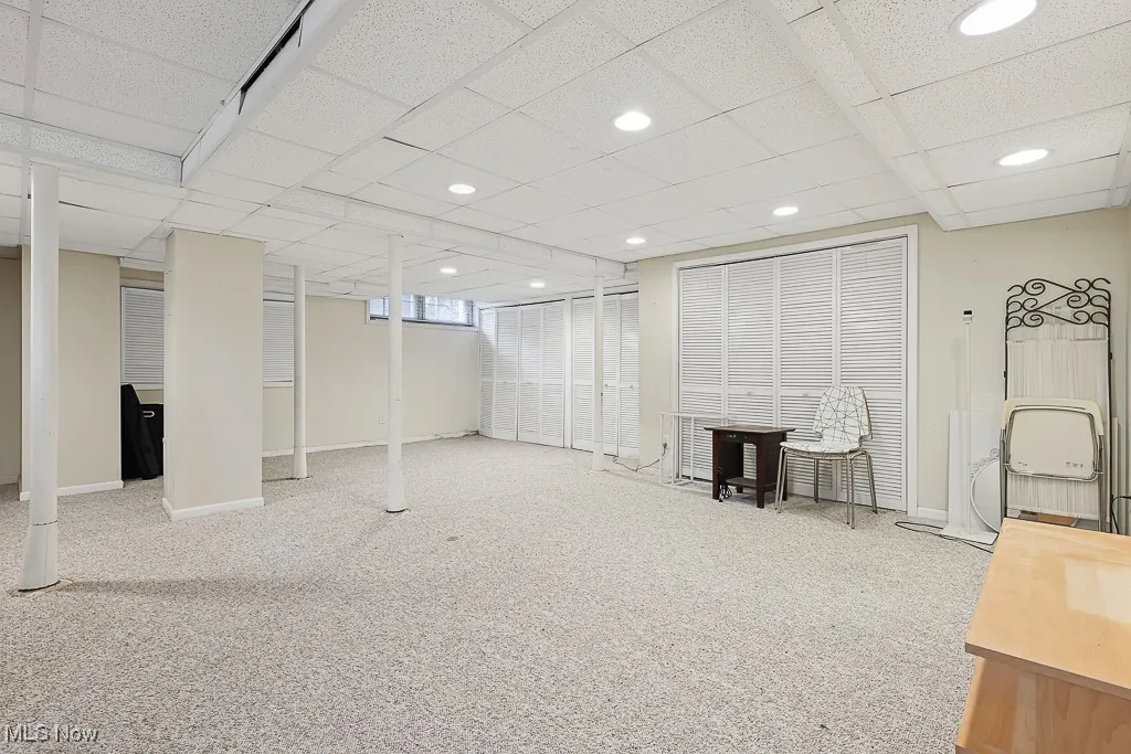 Finished below grade area with a paneled ceiling, carpet flooring, and recessed lighting