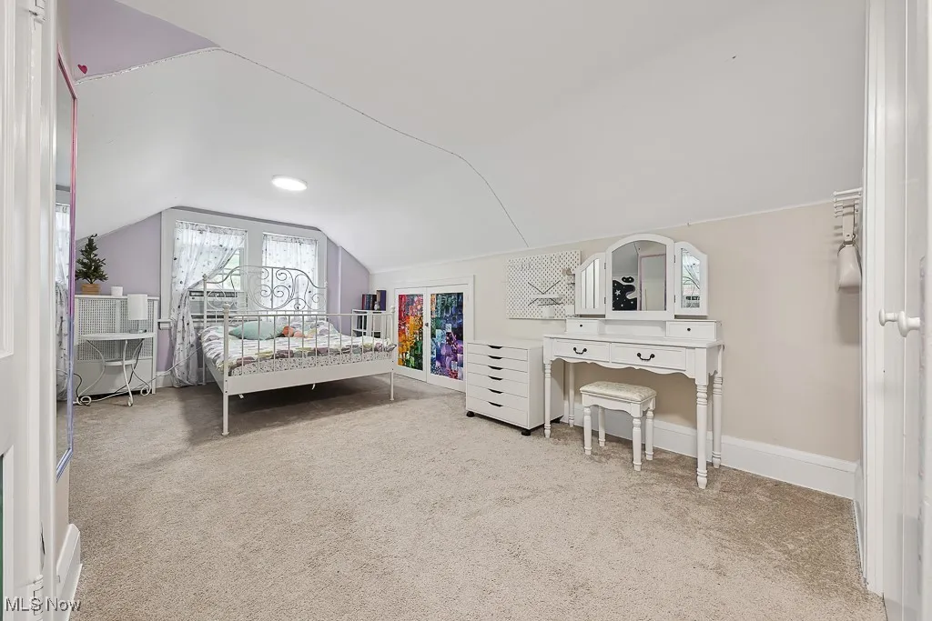 Bedroom with vaulted ceiling and carpet floors
