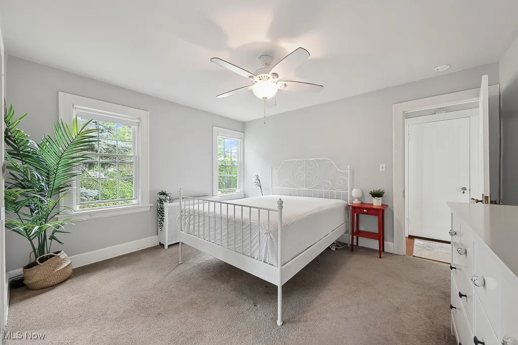 Bedroom with light carpet and a ceiling fan