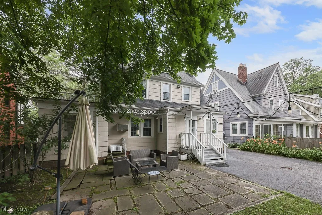 Rear view of property with a patio and a shingled roof