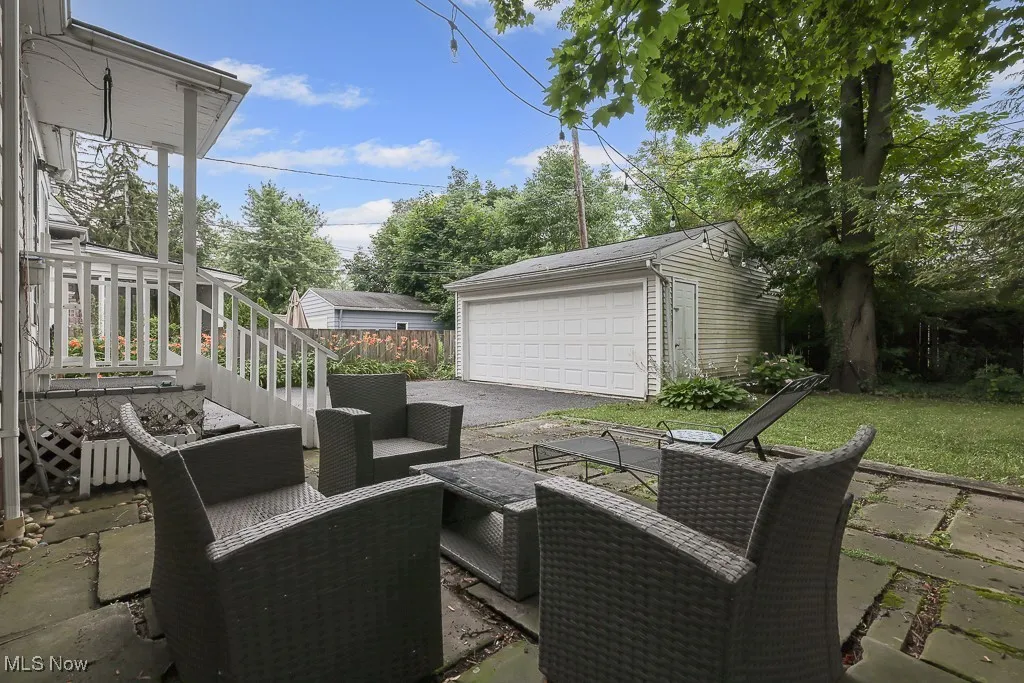 View of patio with a detached garage, an outdoor structure, and an outdoor living space