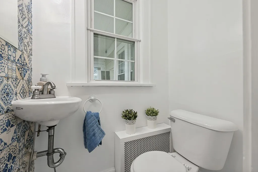 Half bathroom with toilet and radiator