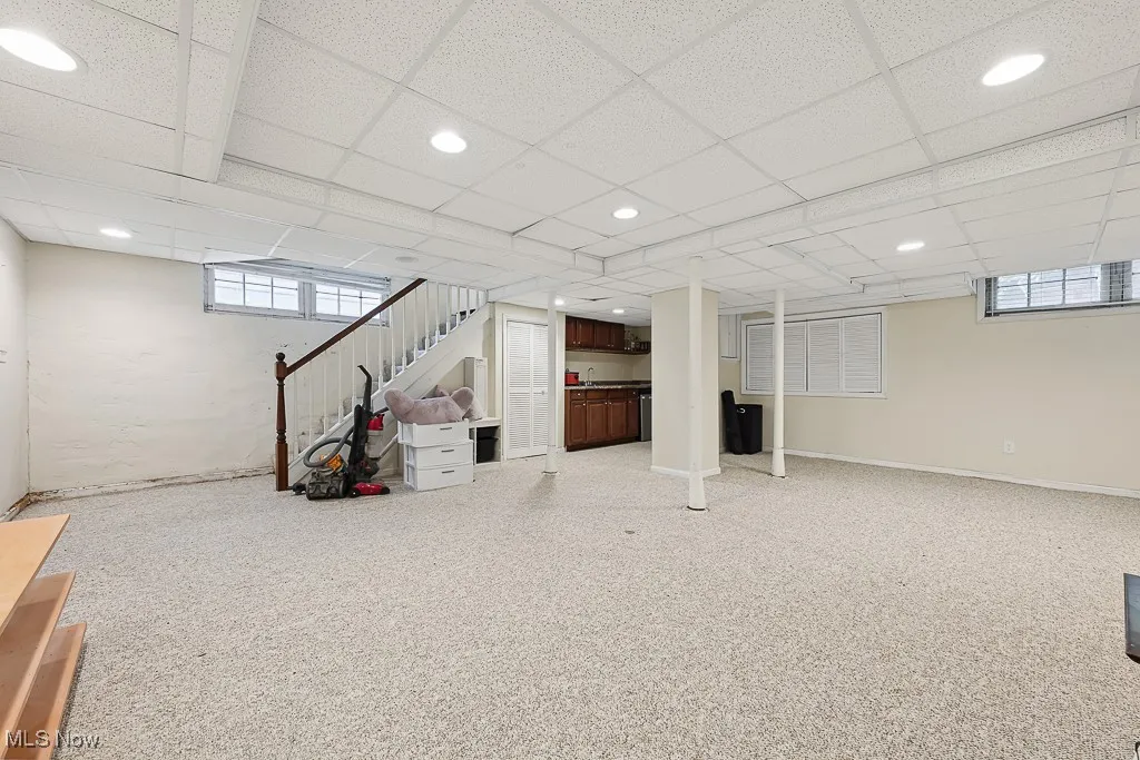 Below grade area with a drop ceiling, recessed lighting, and stairway