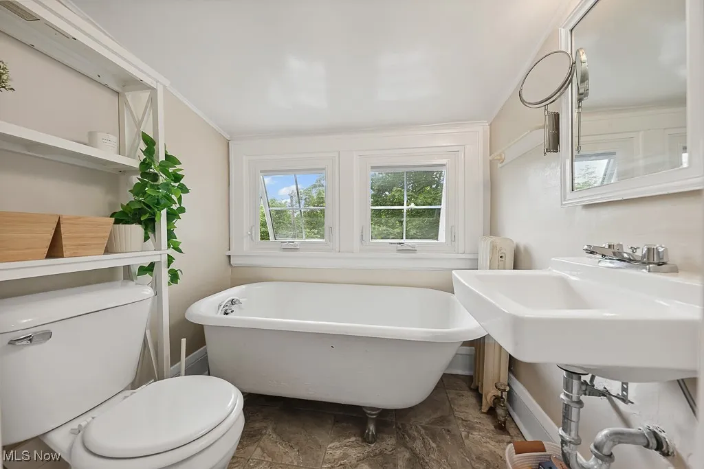 Bathroom with a freestanding tub and ornamental molding