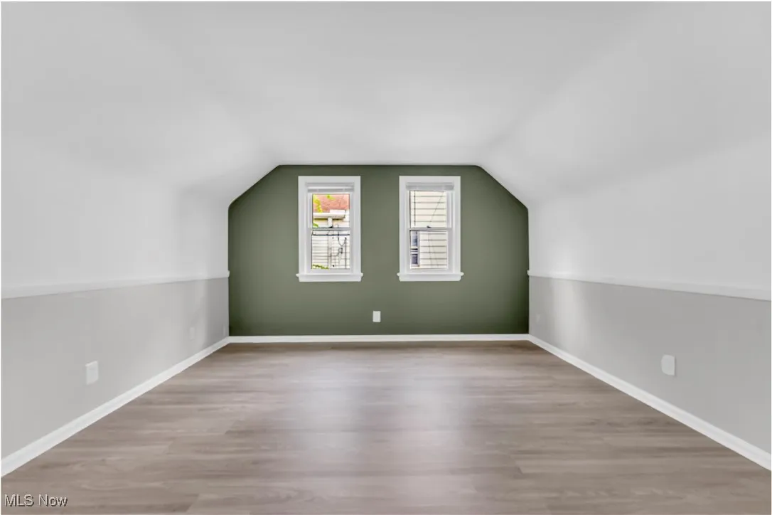 Additional living space with wood finished floors and lofted ceiling