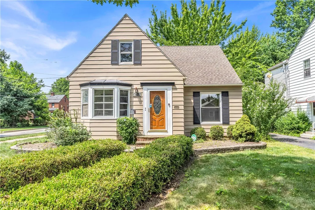 Bungalow featuring a shingled roof and a front yard