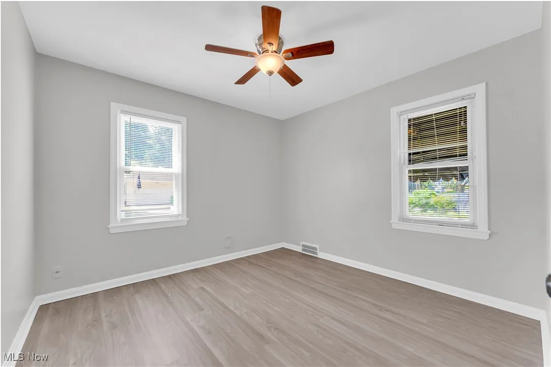 Empty room featuring wood finished floors and a ceiling fan