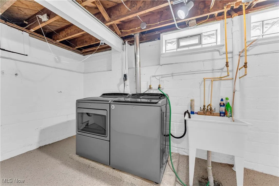 Basement with washer and clothes dryer and a sink
