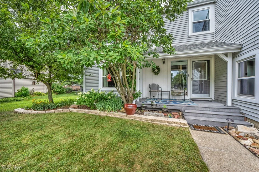 View of grassy yard featuring covered porch