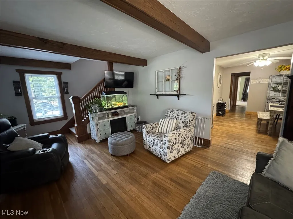 Living area featuring beam ceiling, wood bannister and railings