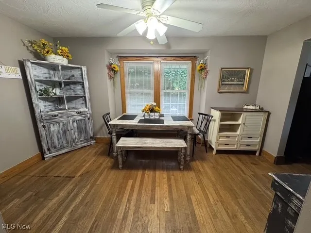 Dining space featuring a textured ceiling, ceiling fan, and wood finished floors