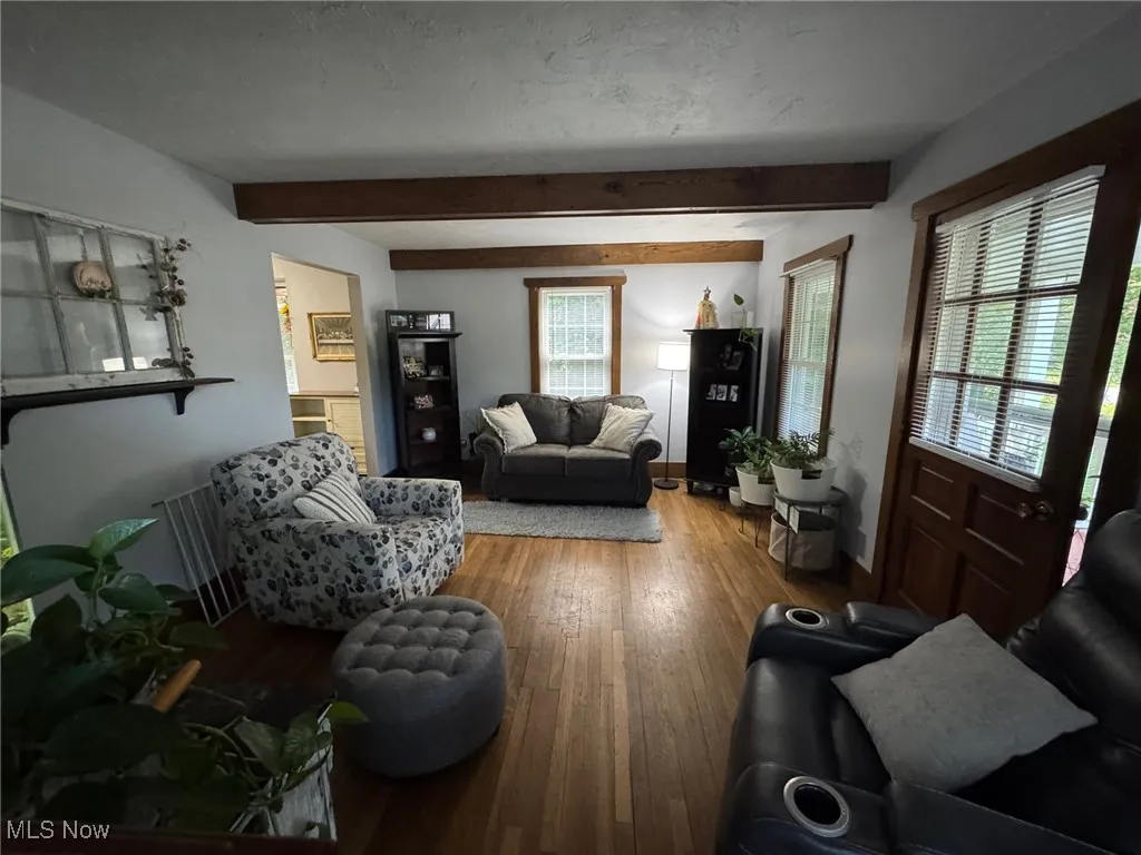 Living area featuring hardwood / wood-style flooring and beamed ceiling