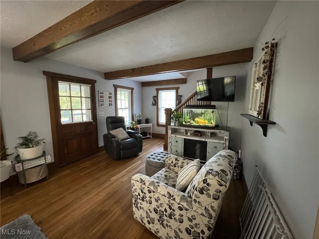 Living room with wood finished floors, and front door