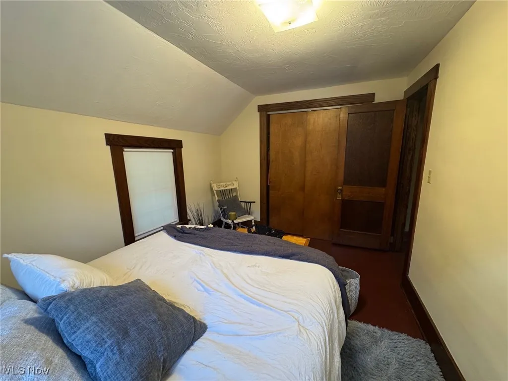 Bedroom featuring lofted ceiling, and a closet