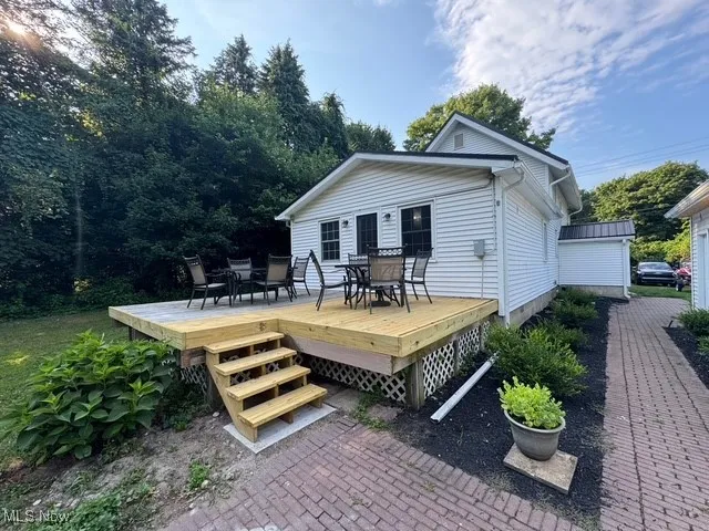 Back of home featuring outdoor gathering space and brick walkway