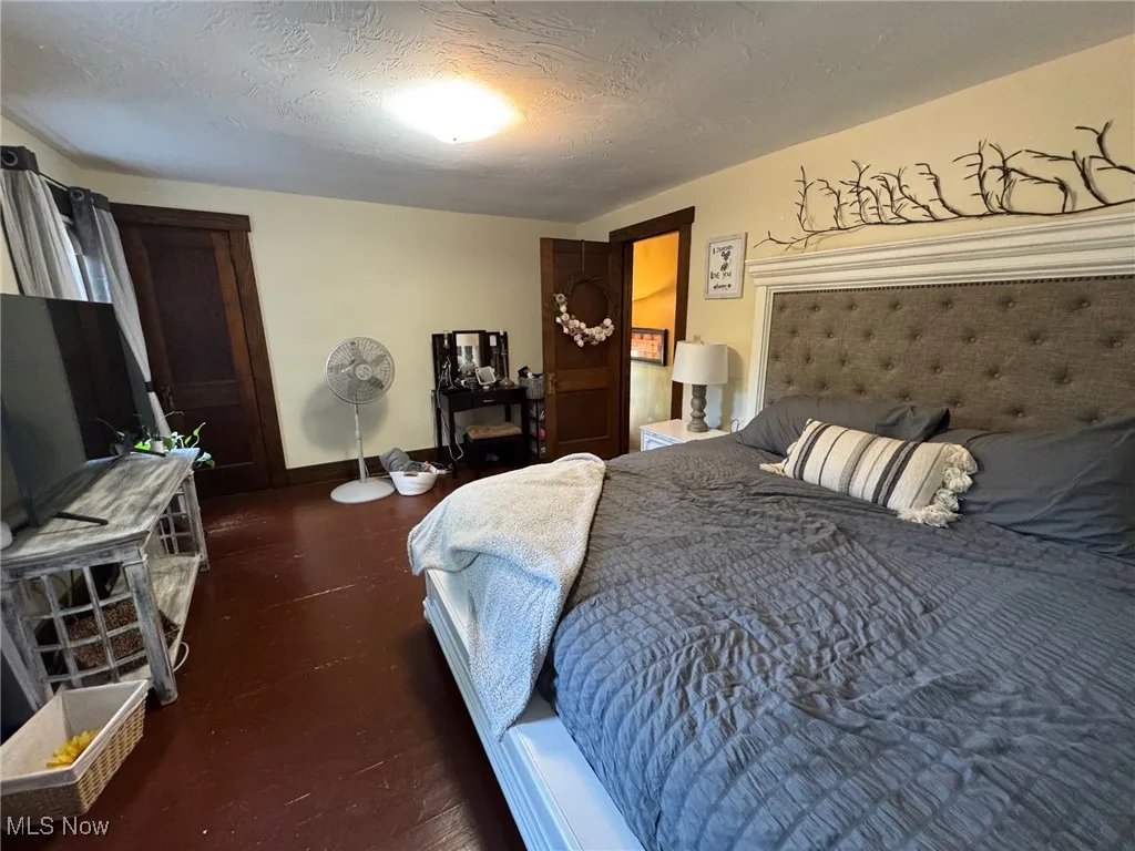 Bedroom featuring wood floors and baseboards