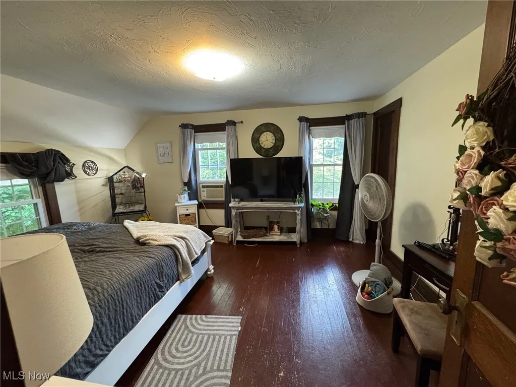 Bedroom featuring wood-type flooring, and lofted ceiling