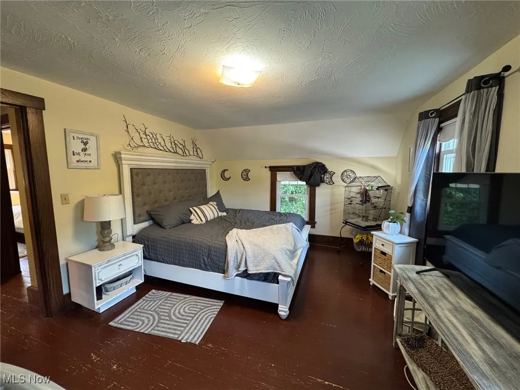 Bedroom featuring wood finished floors and textured ceiling
