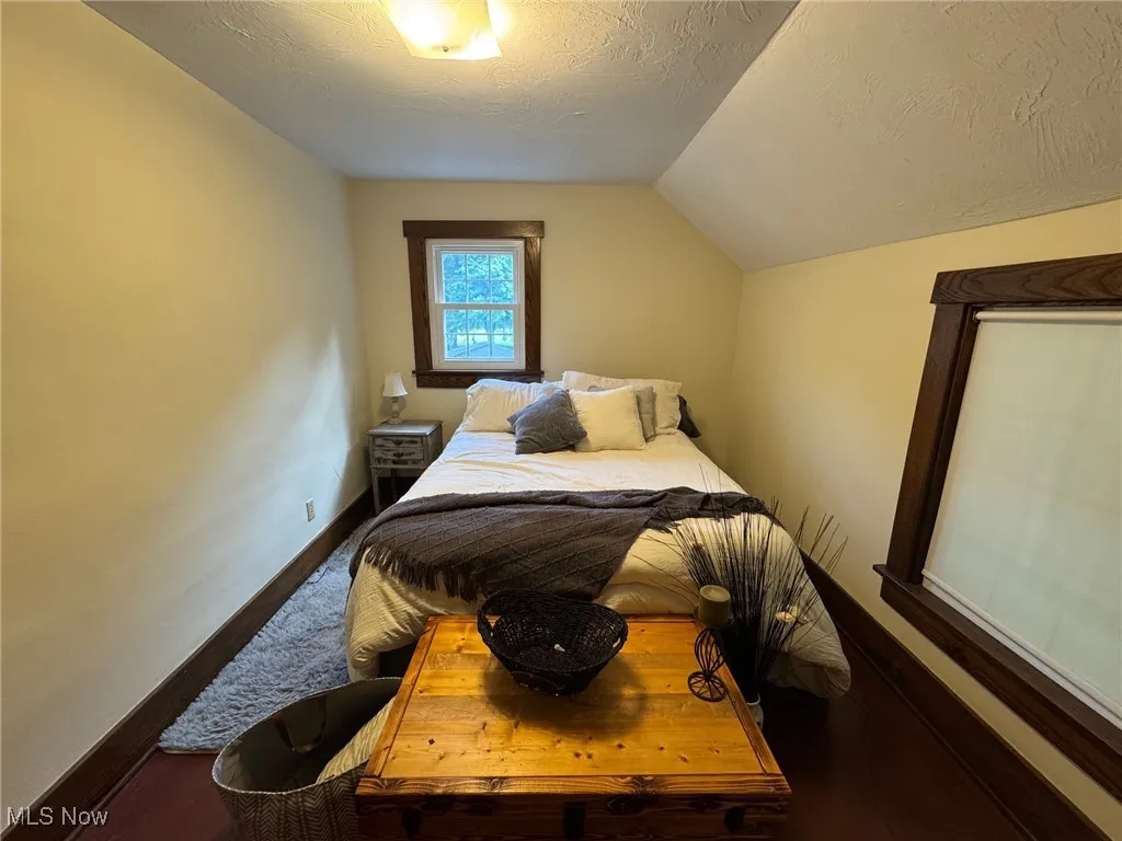 Bedroom featuring a lofted ceiling and wood floor