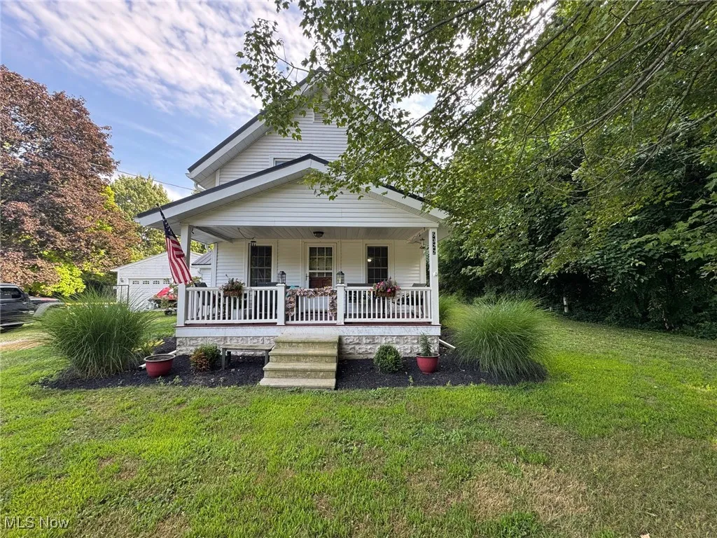 View of front of home with covered porch and a front yard