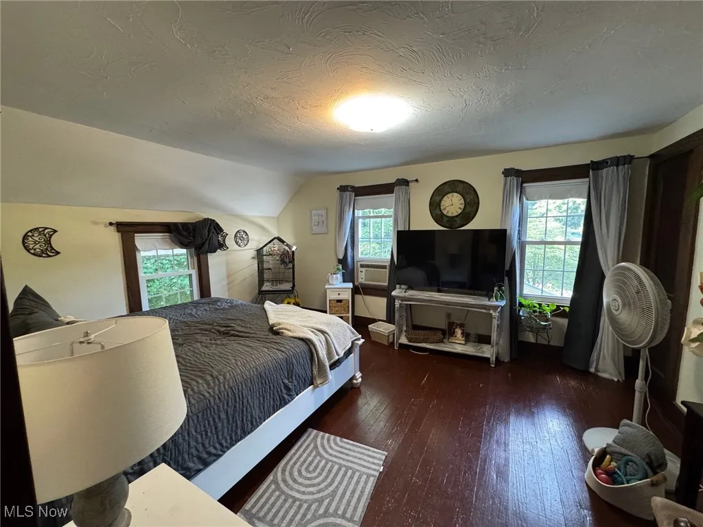 Bedroom with hardwood / painted wood-style flooring, and plenty of light