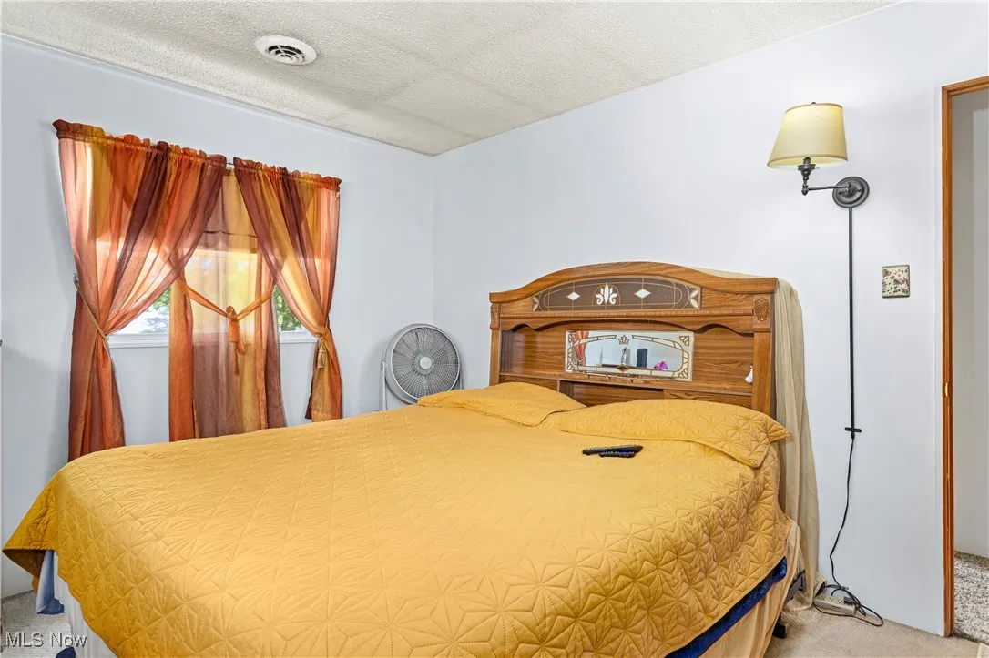 Bedroom featuring carpet flooring and a textured ceiling