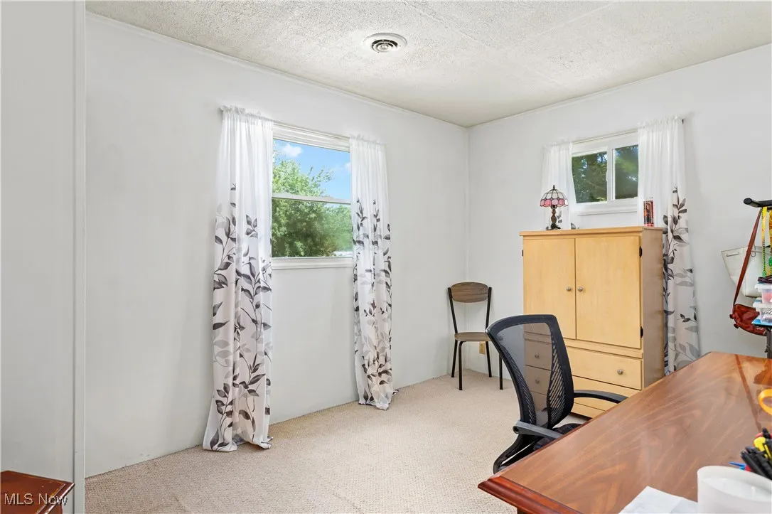 bedroom with light carpet and a textured ceiling