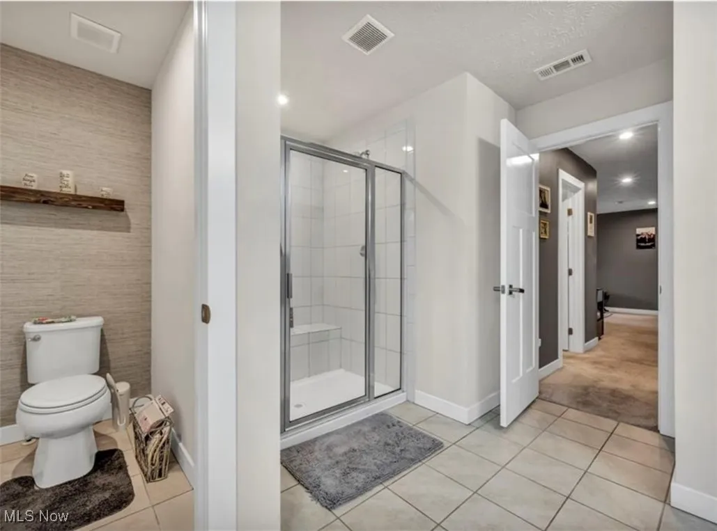 Full bath featuring a stall shower, tile patterned floors, and recessed lighting