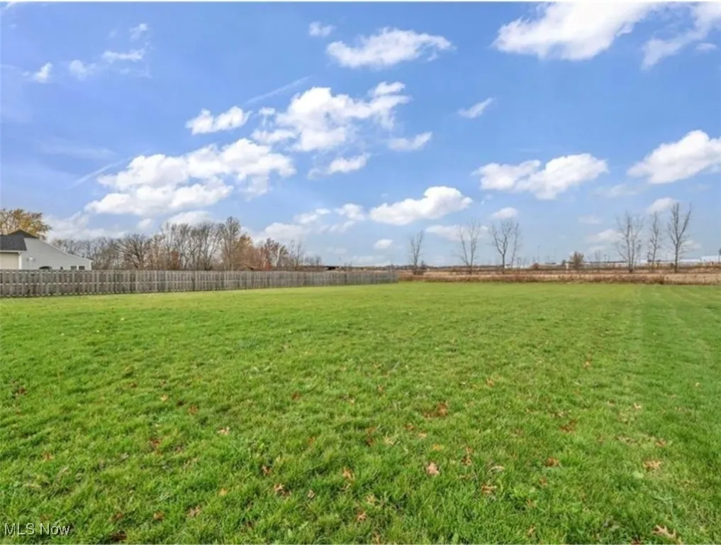 Fenced backyard with a view of countryside