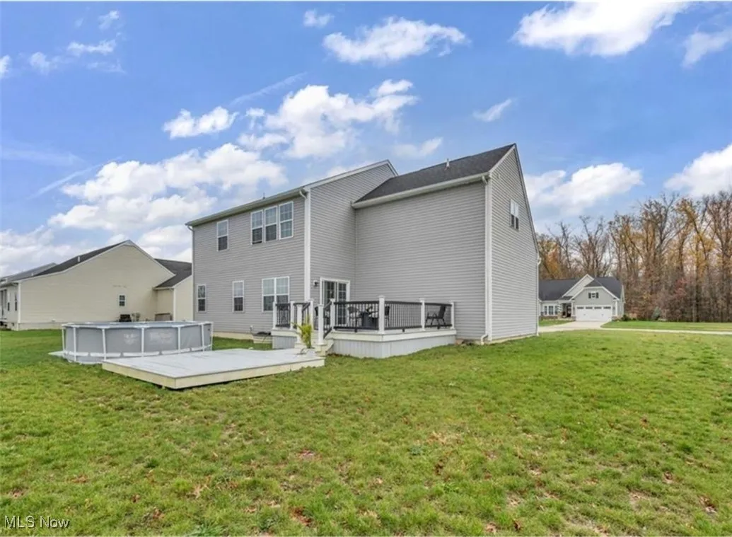 Back of property with a deck and a yard