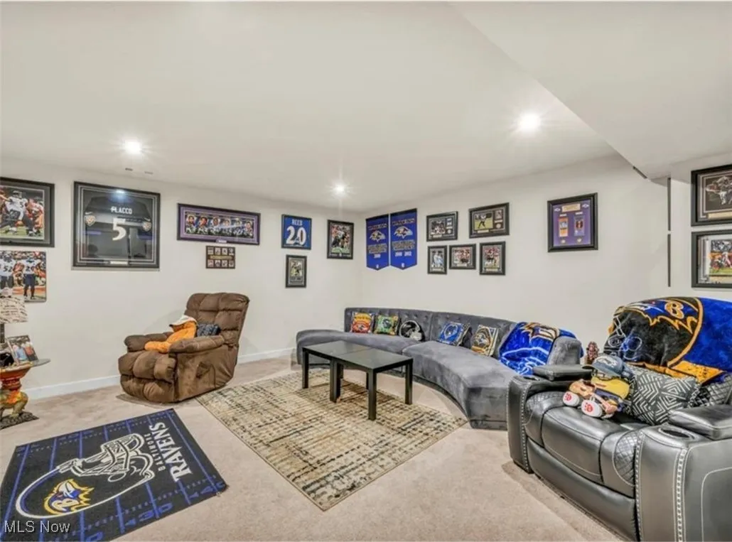 Carpeted living area with recessed lighting and baseboards