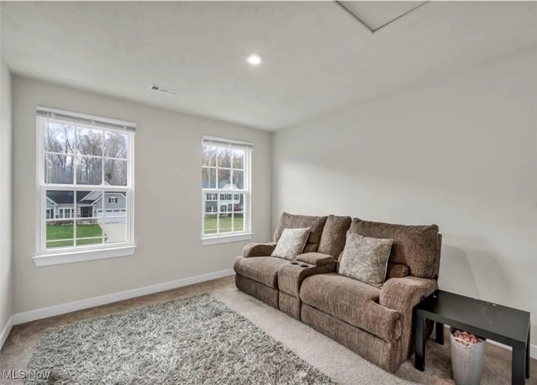 Carpeted living room featuring baseboards and recessed lighting